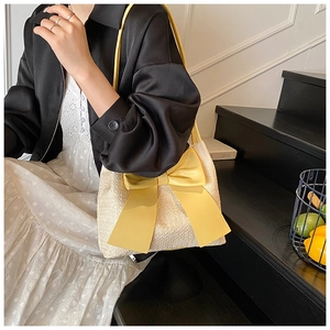 Détail du sac seau en tweed avec grand nœud jaune et fine bandoulière élégante