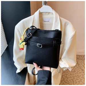 Détail du sac seau noir en cuir grainé avec un petit pendentif canard jaune décoratif