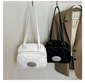 Détail de la texture gaufrée à nœuds et logo en métal sur les sacs fourre-tout