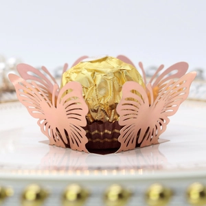 Macro detail of laser-cut rose gold butterfly chocolate wrapper for weddings