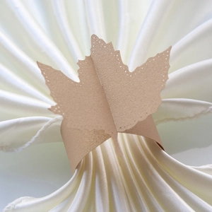 Macro detail of champagne gold maple leaf paper napkin ring with laser-cut hollow dots