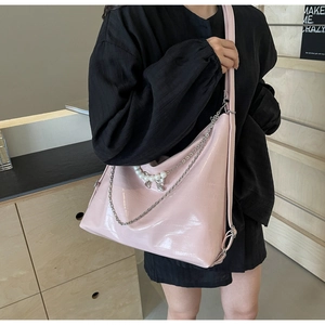 Detail der rosa Hobo-Tasche mit Krokodil-Prägung, Perlen-Schleife und Silberkette