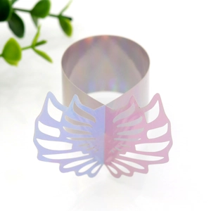 Detailed macro view of iridescent holographic angel wing paper napkin ring for weddings
