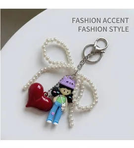 Detail of vintage pillow bag with pearl bow, red heart charm, and cute doll pendant