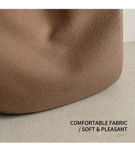 Close-up of litchi-grain leather texture with embossed logo on a hobo bag