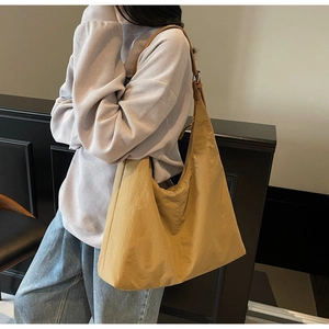Detail of large mustard yellow hobo bag with textured fabric and wide shoulder strap