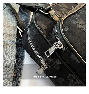 Gros plan du sac à bandoulière en tissu jacquard noir avec fermeture éclair argentée