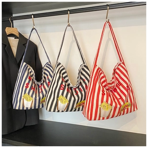 Vue détaillée de grands sacs cabas en toile rayée avec broderie en bleu, noir et rouge