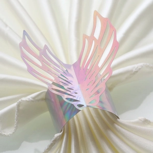 Holographic angel wing napkin ring with laser cut details on white pleated fabric