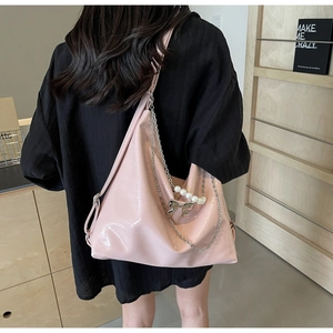 Detail der rosa Hobo-Tasche mit Silberkette, Perlen und metallenem Schleifenanhänger