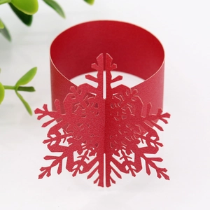 Macro shot of laser-cut red snowflake paper napkin ring for Christmas table decor