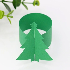 Détail du rond de serviette en papier miroir vert avec sapin de Noël 3D sur fond blanc
