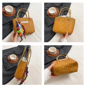 Detail view of woven straw tote bag featuring colorful charms and drawstring lining