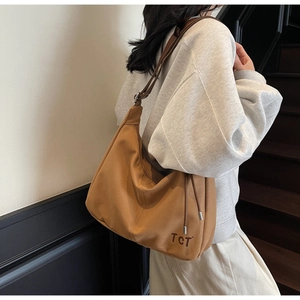 Detailansicht der braunen Canvas Hobo-Tasche mit TCT-Aufdruck und Metall-Kordelzug