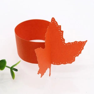 Detailed macro view of orange paper napkin rings with laser-cut leaf patterns for events