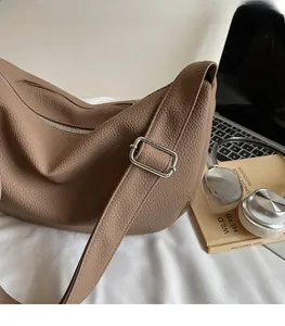 Detail of lychee textured leather hobo bag with adjustable strap and silver zipper