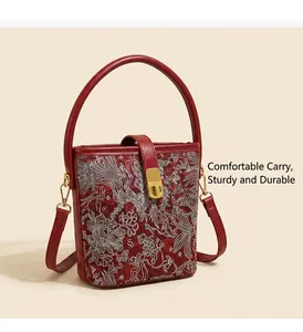Detail of red Chinese embroidery handbag featuring silver phoenix pattern and metal clasp