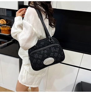 Détail du sac à bandoulière avec texture jacquard florale et plaque en métal argenté