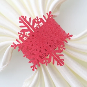 Detail of red snowflake paper napkin rings with subtle glitter finish for holiday decor