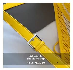 Detail of adjustable yellow leather strap with silver metal buckle on woven tote bag