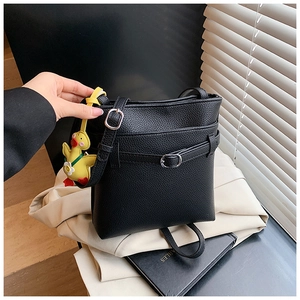 Détail du sac seau noir grainé avec boucle métallique et charmant pendentif canard jaune