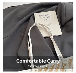 Detail of white handles on a woven tote bag featuring wavy geometric stripe texture