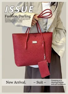 Detail of red tote bag featuring intricate V-weave texture and small hanging pouch