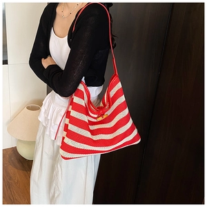 Detail of red and white striped canvas tote with leather trim and bamboo clasp