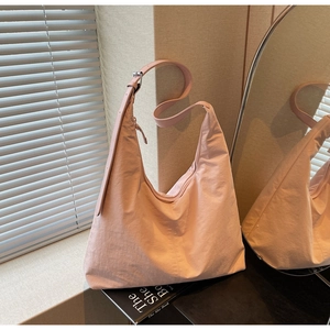 Macro detail of the soft pink tote bag texture with adjustable strap and shadow play