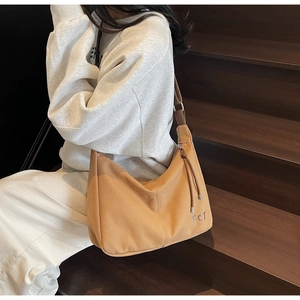 Detailansicht der karamellfarbenen Canvas-Tasche mit TCT-Stickerei und Reißverschluss-Quaste