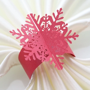 Macro view of red laser-cut snowflake paper napkin ring with glitter pearl finish