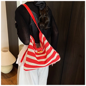 Detail of red and white striped knit hobo bag with a wooden toggle button closure