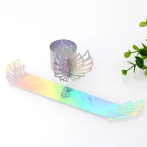 Detail view of iridescent laser-cut paper napkin rings with hollow angel wing design
