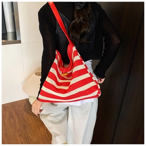 Detail of red and white woven tote bag featuring net texture and wooden toggle closure