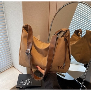 Detailaufnahme der Canvas-Tasche mit braunem Lederbesatz und weißen Kontrastnähten