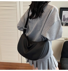 Detail of black pebbled leather hobo bag with adjustable strap and minimalist design