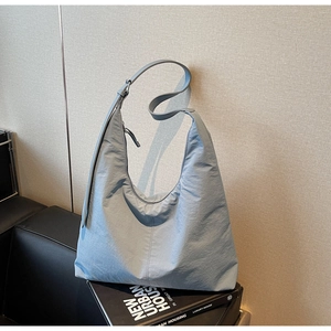 Detail view of large grey-blue hobo shoulder bag with textured fabric and wide strap