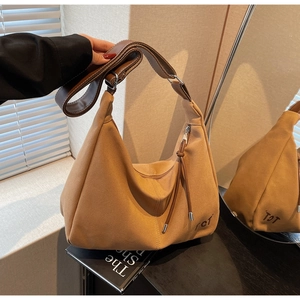 Detail der braunen Canvas-Hobo-Tasche mit Halbmondform und Quasten-Reißverschluss
