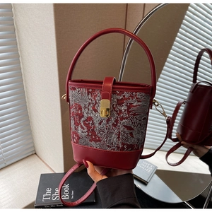 Detailed embroidery of a dragon pattern on the red Chinese style bucket handbag