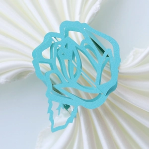 Close-up of laser-cut light blue rose paper napkin ring for elegant wedding table settings