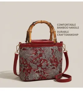 Detailed view of red embroidery fabric and natural bamboo handle on a retro handbag