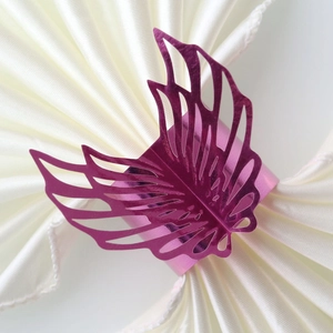 Macro shot of purple iridescent hollow butterfly napkin ring on a white linen napkin