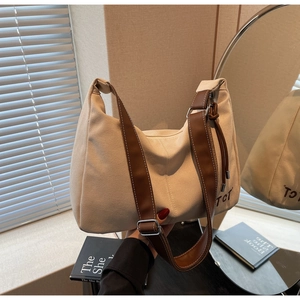 Detailaufnahme der beigen Canvas-Tasche mit braunen Lederriemen und TCT-Stickerei