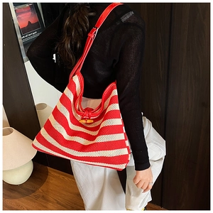 Detail of red and white striped knit shoulder bag with wood clasp and leather strap