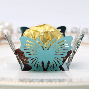 Detailed teal hollow butterfly laser cut wrapper holding a gold foil chocolate ball