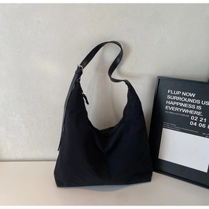 Detail view of large black Hobo bag with adjustable leather strap and silver buckle