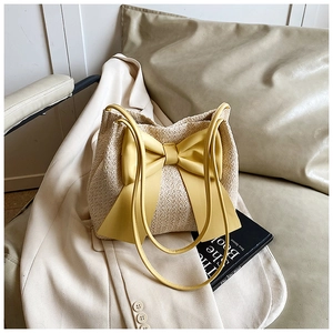 Gros plan détaillé du sac cabas en paille avec un grand nœud jaune décoratif élégant