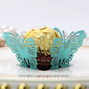 Macro detail of laser-cut teal butterfly candy wrapper with Ferrero chocolate