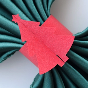 Détail macro du rond de serviette sapin de Noël rouge avec étoile sur satin vert