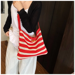 Close-up of red and white striped woven tote bag with wooden bamboo clasp detail